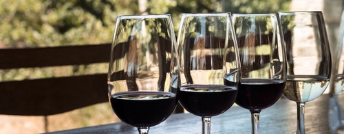 Close up view of wine glasses on table at wine tasting in Urla district of Izmir province in Turkey. It is a sunny summer day.