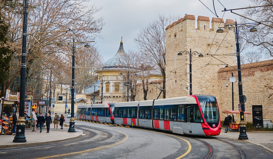 04.03.2021. istanbul turkey. Public transportation tram passing near the Hagia Sophia mosque during rainy and overcast weather with street food sellers and walking people and tourist. istanbul tram