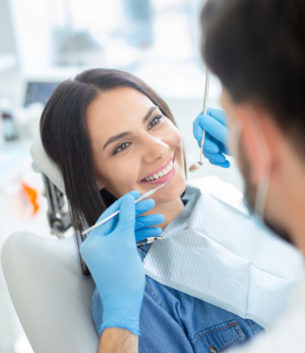 smiling female patient at dental procedure in modern dental clinic
