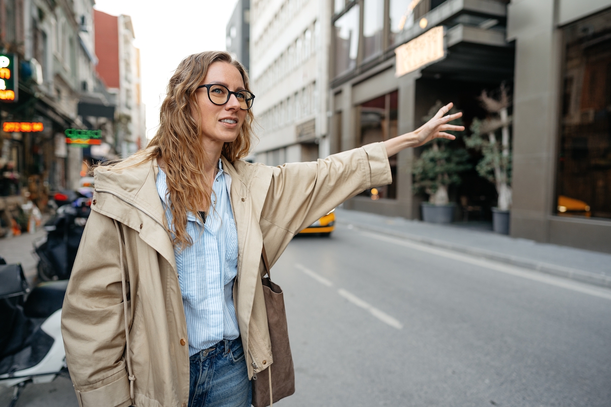 Young casual caucasian woman catching a taxi in Istanbul